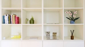 A bookshelf with books, a potted cactus, and a vase with flowers. - Bright Urban Terrace | Porta Romana (Milan)