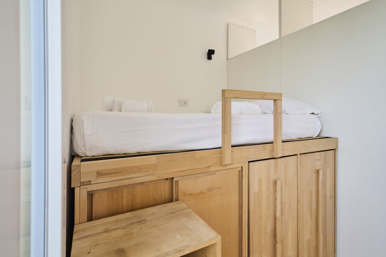 Une chambre à coucher avec un lit, un banc en bois et une petite table.