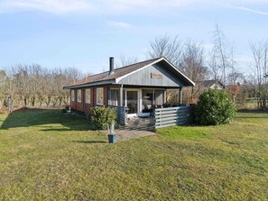 A two-story house with a covered porch and a chimney. - 5 Star Holiday Home in Ronne (Ronne)
