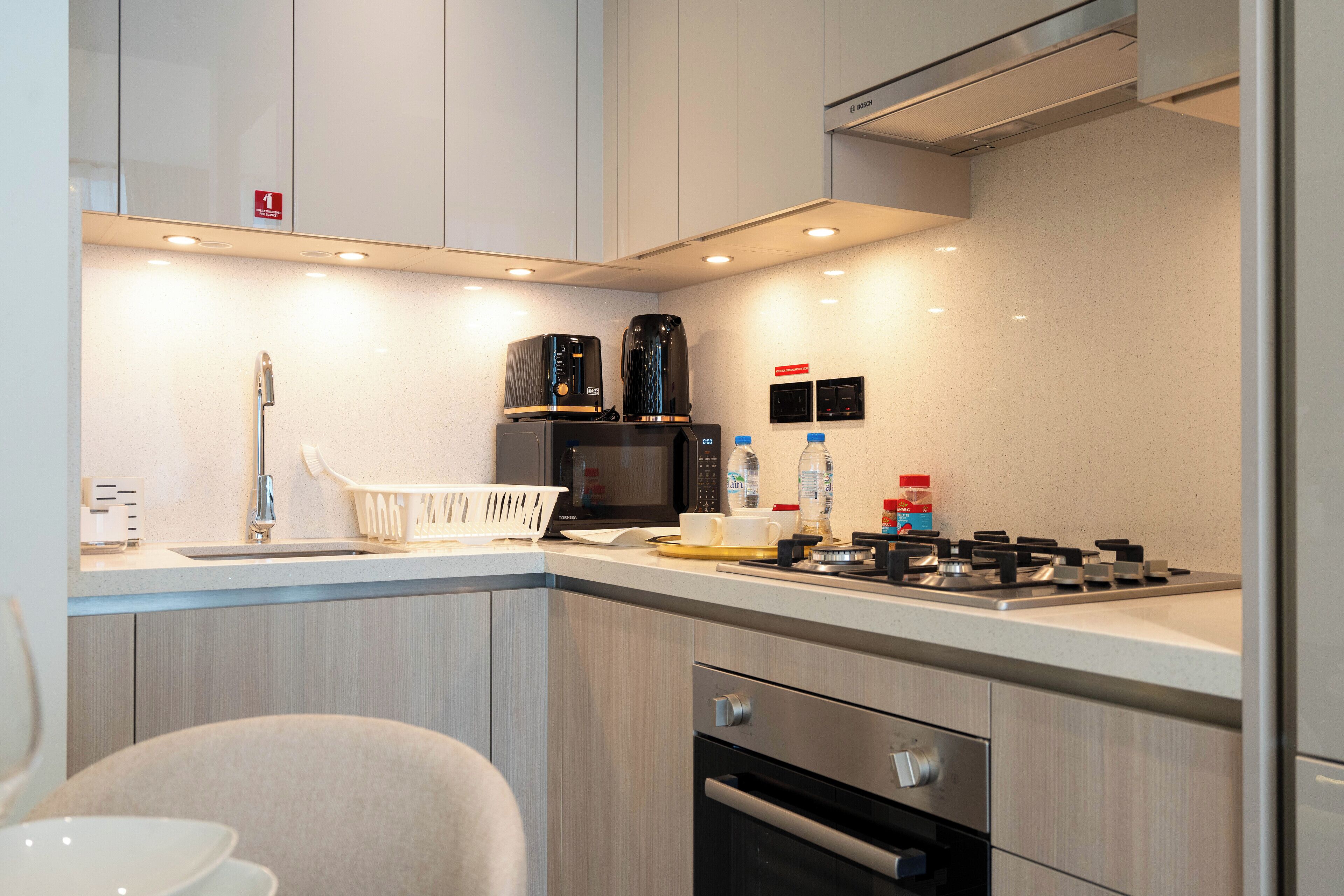 Una cocina moderna con microondas, estufa y lavaplatos.