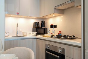 Deluxe appartement, uitzicht op de stad | Privékeuken | Een koelkast, een microgolfoven, een oven, een kookplaat