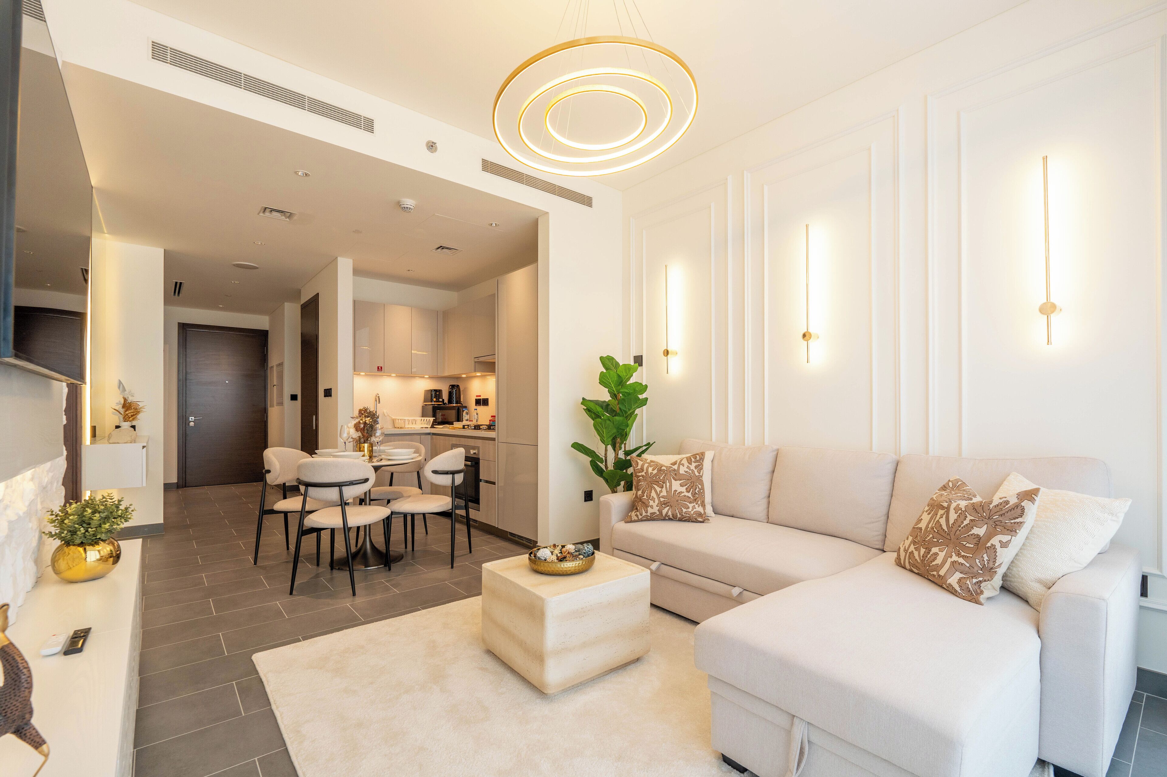 A modern living room with a sofa, ottoman, and dining area.