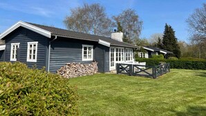 A two-story house with a dark exterior, white trim, and a covered porch. - 5 Star Holiday Home in Kirke Hyllinge (Kirke Hyllinge)