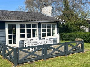 A house with a porch, white-framed windows, a chimney, and a fenced yard. - 5 Star Holiday Home in Kirke Hyllinge (Kirke Hyllinge)