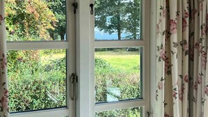 A four-pane window with a view of a garden and trees. - 5 Star Holiday Home in Kirke Hyllinge (Kirke Hyllinge)