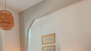 Une chambre à coucher bien rangée, avec un lit, des lampes de chevet et deux œuvres d’art encadrées accrochées au mur.