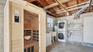 A sauna room with a control panel, a wooden bench, and a bench seat. - Private Beach Access Sauna Outdoor Fireplace (St. Augustine)