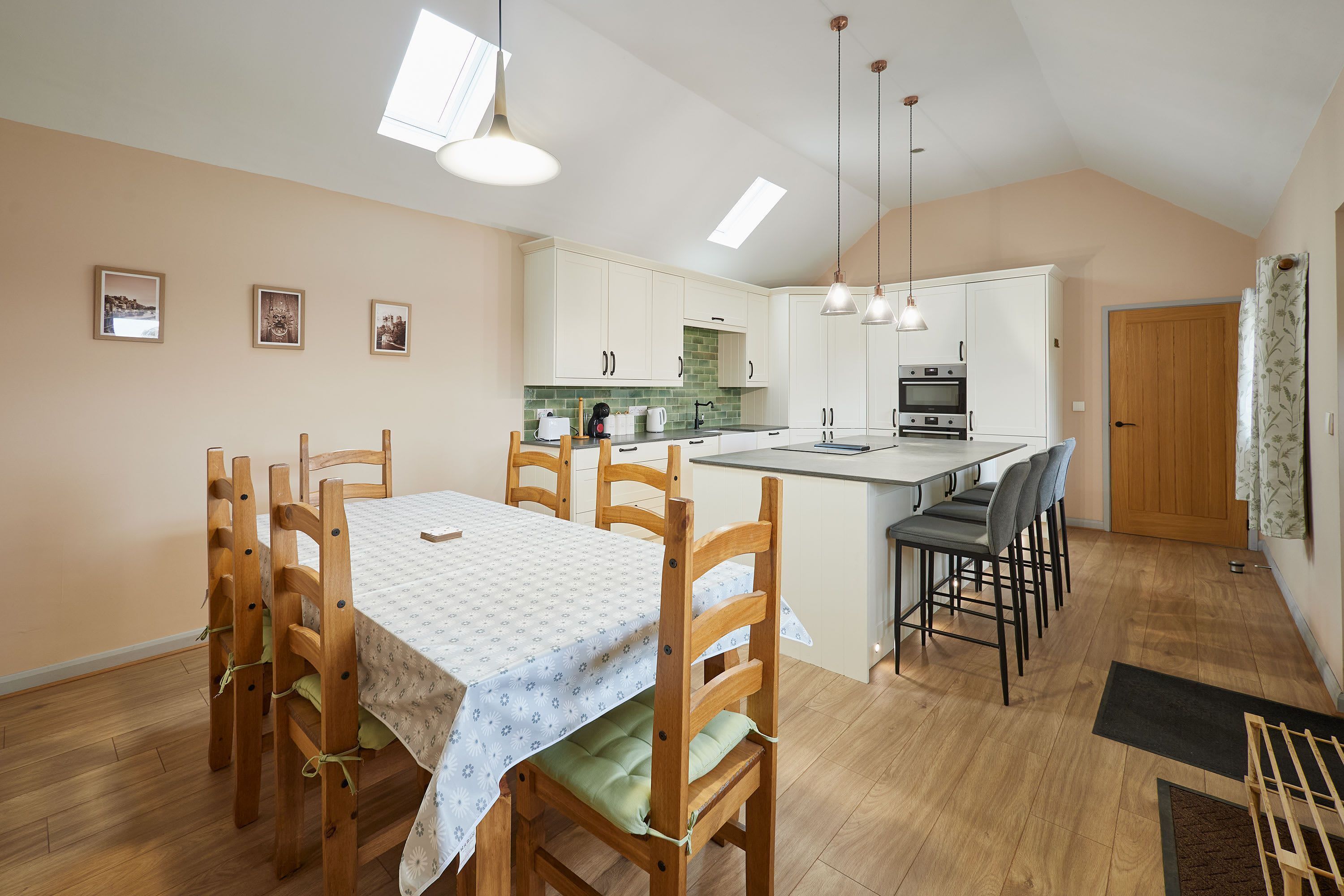 A modern kitchen with white cabinets, a central island, and pendant lighting.
