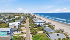 Uma área residencial costeira com casas, uma praia e um cais.