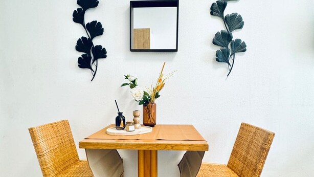 A dining table with two chairs, a vase with flowers, and wall decorations. - Comfortable and Affordable Palace Studio (Vienna)