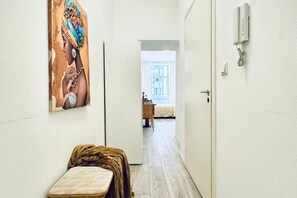 A narrow hallway with a bed, a bedside table, a telephone, and a painting on the wall. - Comfortable and Affordable Palace Studio (Vienna)