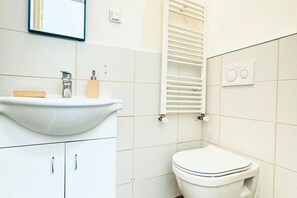 A bathroom with a white sink, toilet, and towel rack. - Comfortable and Affordable Palace Studio (Vienna)