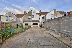 A residential street with houses, a paved driveway, and a brick wall. - Cosy 3-bedroom House Near Caerphilly Castle (Caerphilly)