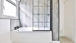 Un baño moderno con bañera, cabina de ducha y ventana.
