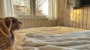Un cane seduto su un letto con una coperta bianca e soffice.
