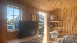 A small, wooden-paneled room with a white desk, a television, two chairs, a bunk bed, and a window. - 4 Star Holiday Home in Skaelskor (Skælskør)