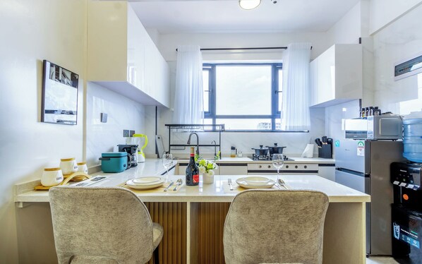 A modern kitchen with a central island, a built-in stove, and a refrigerator.