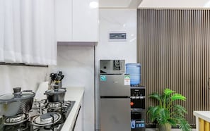 A modern kitchen with a gas stove, a stainless steel refrigerator, and a water dispenser.