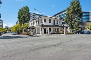 Ein Hotel mit zweigeschossigem Bau, überdachter Eingangsparte und Parkplatz.