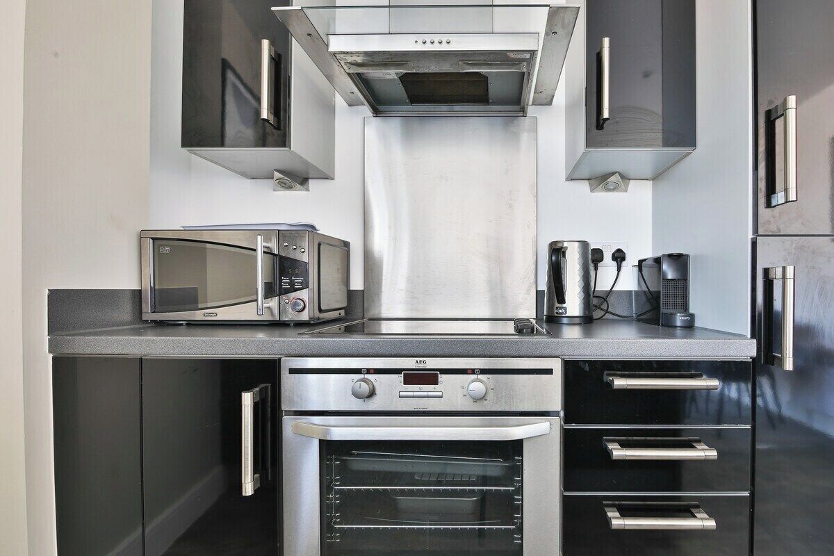 Eine moderne Küche mit integriertem Mikrowellenherd, Backofen und Kaffeemaschine.