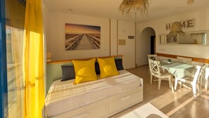 A bedroom with a bed, a desk, and a dining area. - 25 - Livingtarifa The Island (Tarifa)