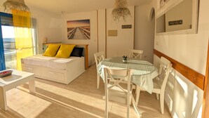 A bedroom with a bed, bedside table, and a view of the sea. - 25 - Livingtarifa The Island (Tarifa)