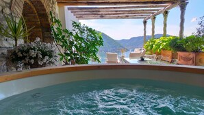 A hot tub with a view of mountains, surrounded by potted plants and a wooden pergola. - Nestled on the hillside of Cernobbio, this enchanting 1608 structure, once a Convent, has undergone a meticulous restoration, now comprising three self-contained apartments. This unit with its tasteful décor, ensures a harmonious blend of style and comf (Cernobbio)