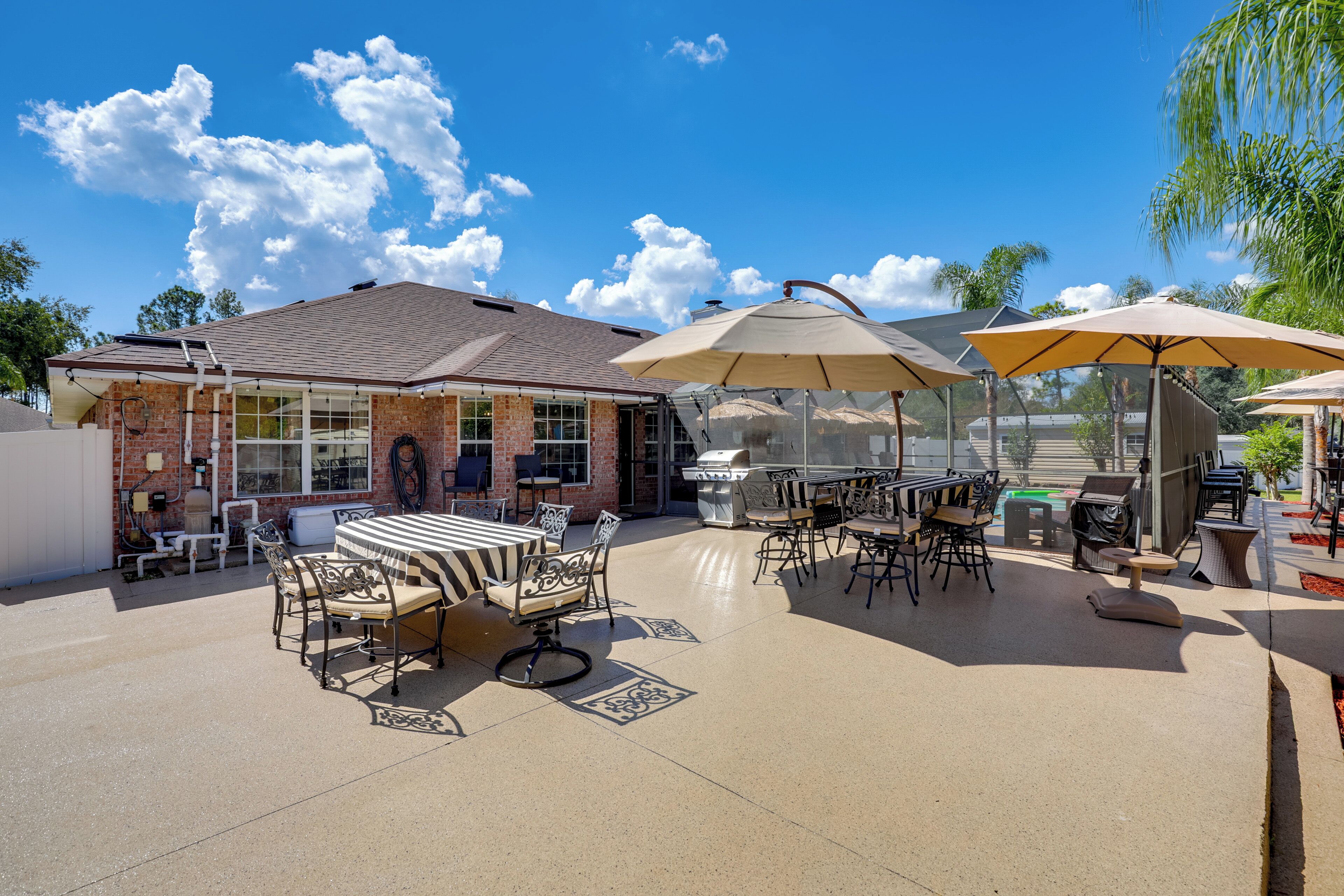 Eine Terrasse im Freien mit einem Ziegelhaus, Gartenmöbeln und Grillplatz.
