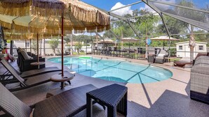 A pool area with lounge chairs and umbrellas. - Backyard Oasis w/ Private Pool: Jacksonville Gem (Jacksonville)