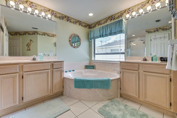 A bathroom with a large bathtub, double vanity with mirrors, and a shower area. - Waterfront Cape Coral Home: Views & Birdwatching (Cape Coral)