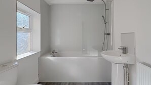 Ein modernes Badezimmer mit Toilette, Badewanne und Waschbecken.
