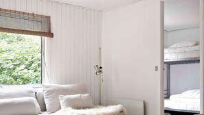 A bedroom with a bed, a bedside table, a lamp, and a radiator.