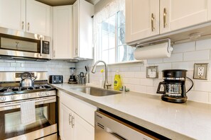 A modern kitchen with stainless steel appliances, a sink, and a coffee maker. - Walkable Location! Sacramento Home w/ Patio (Sacramento)