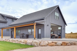 A modern two-story house with a covered patio, a garage, and a stone retaining wall. - Mtn & Lake Views: Family Retreat in Bear Lake! (Garden City)