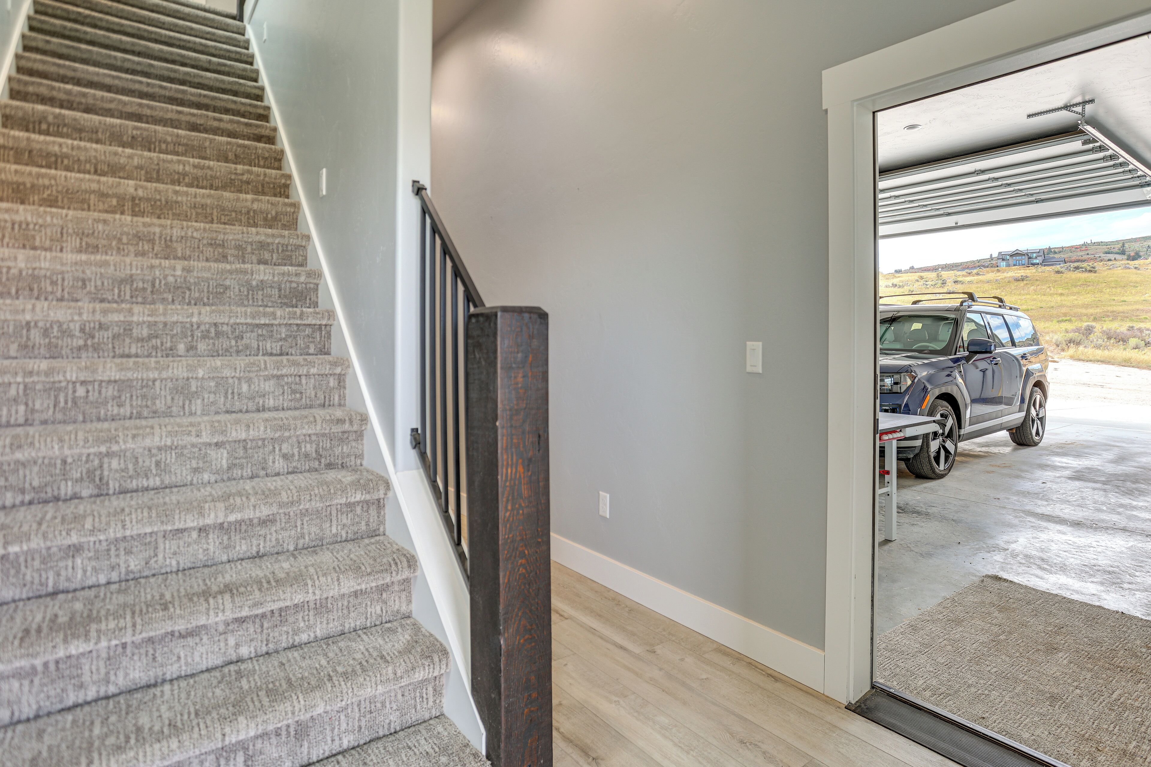 A staircase leading to a garage with a vehicle parked inside.