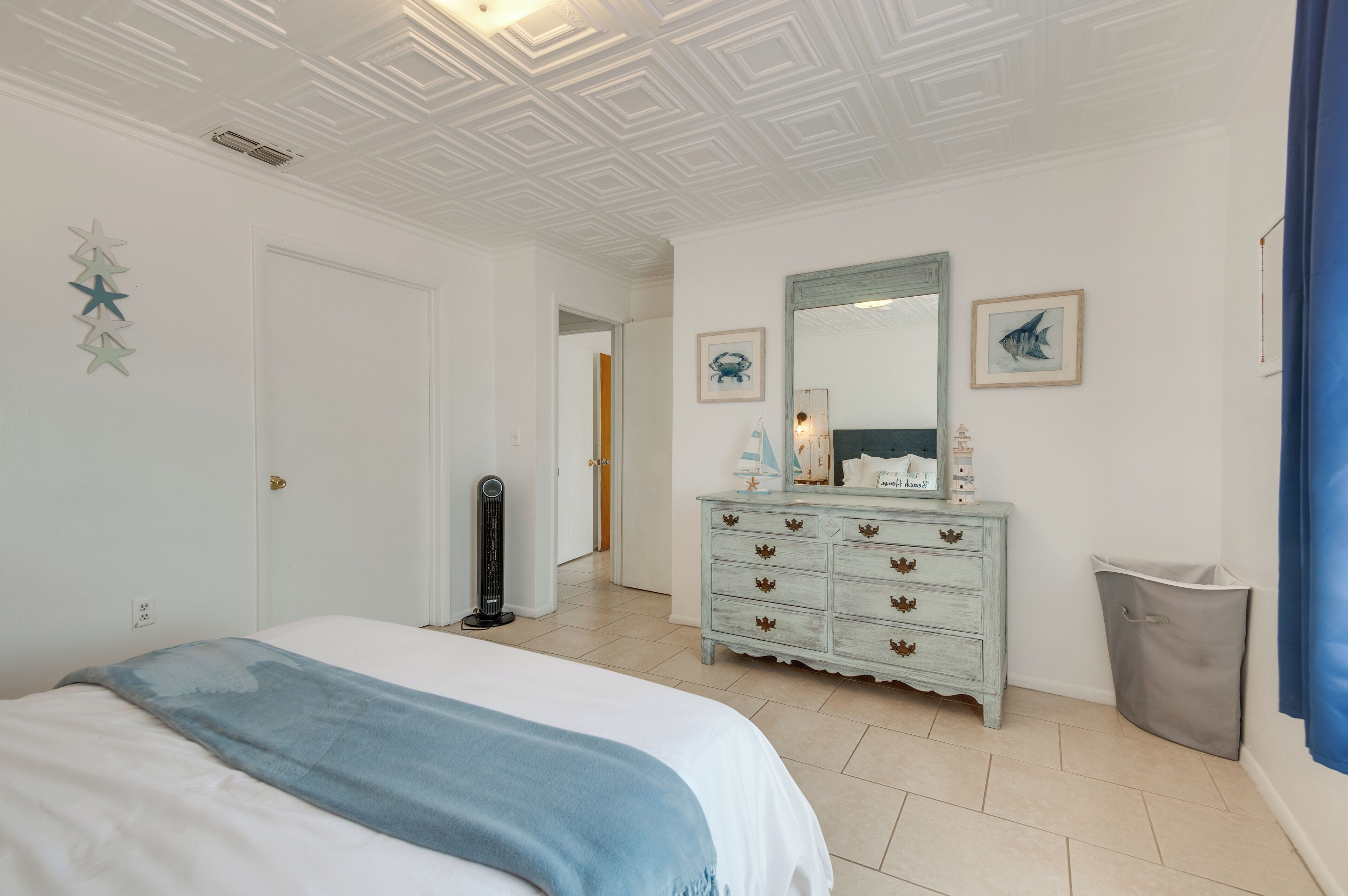 Ein Schlafzimmer mit Bett, Kommode und Spiegel.