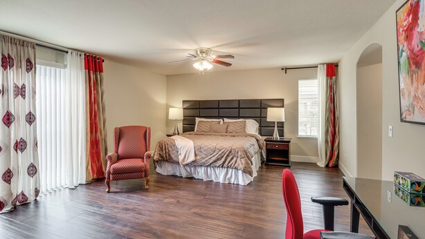 A bedroom with a bed, a chair, a desk, and a ceiling fan. - Grand & Convenient Home 7 Mi to Las Vegas Strip! (Las Vegas)