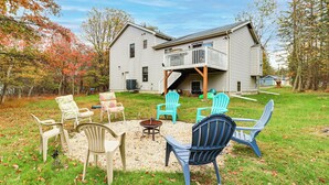 A large house with a balcony, surrounded by a grassy yard with several chairs and a fire pit. - < 1 Mi to Lake: Family Home in Albrightsville! (Albrightsville)