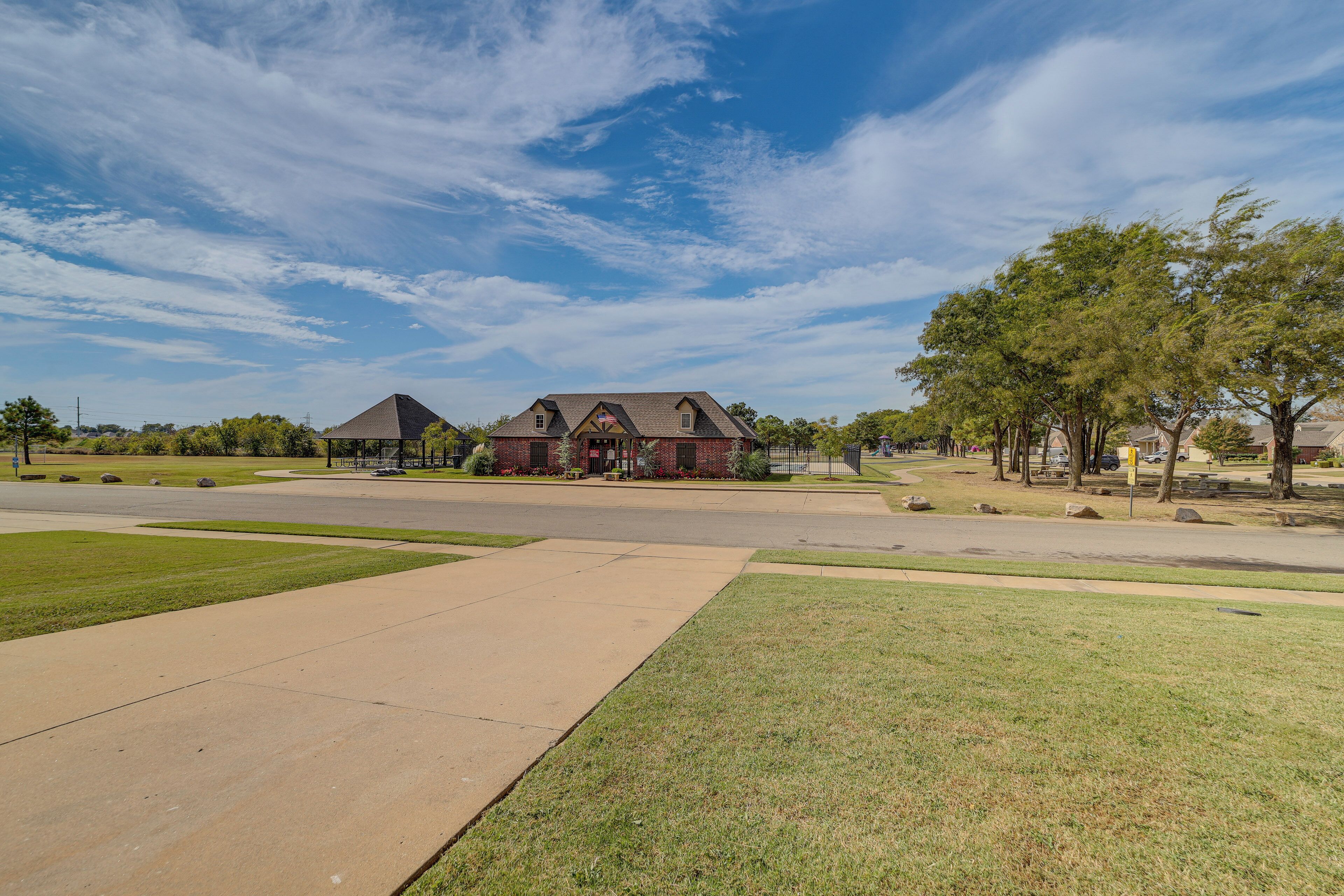 A large house with a prominent front porch, a driveway, and a well-maintained lawn.