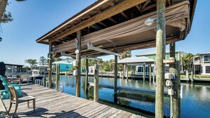 A wooden dock with a covered seating area, a boat, and a water body. - 2 Mi to Beach! Canal-front Escape in Crystal River (Crystal River)