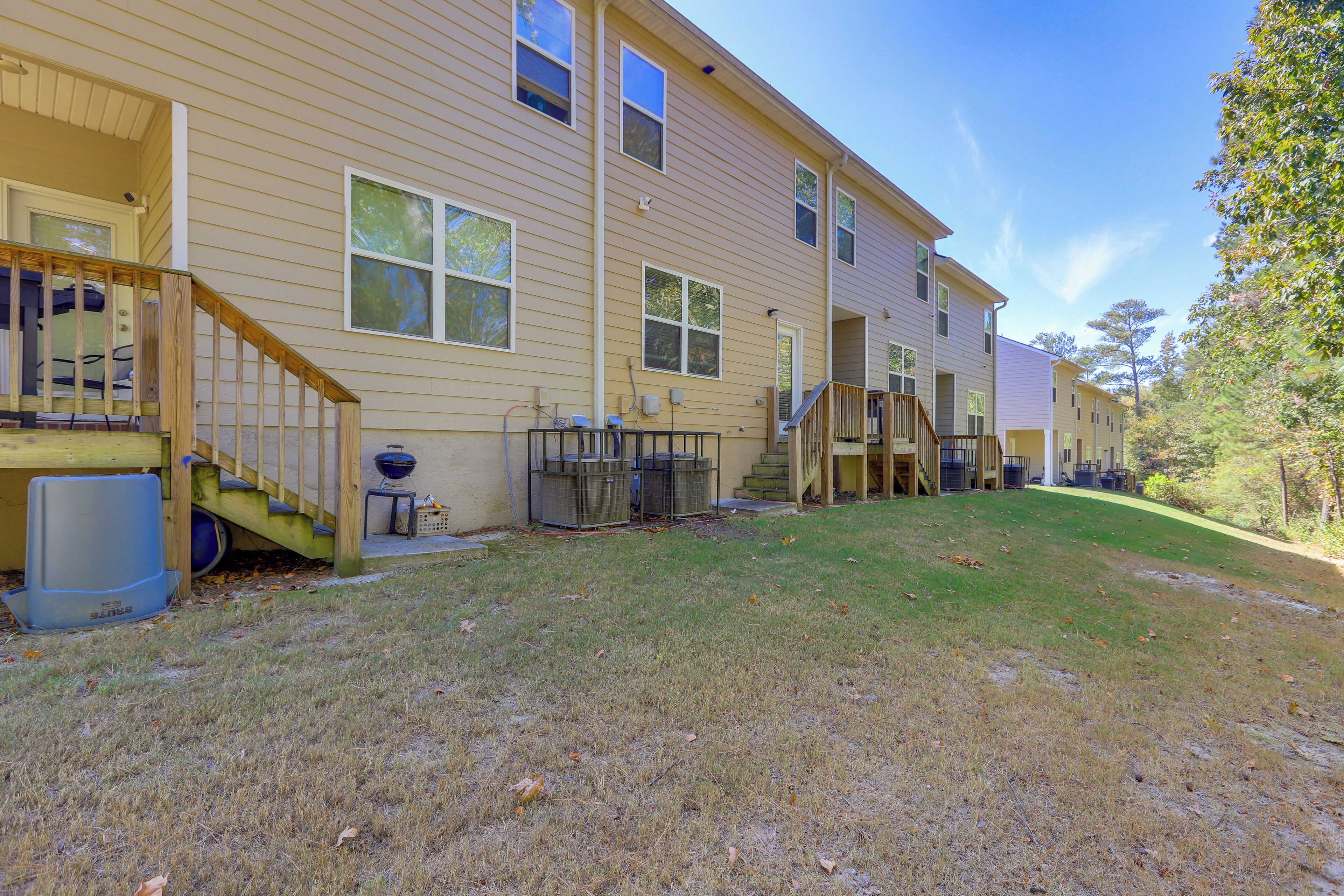 A two-story house with a front porch, a small outdoor seating area, and a covered staircase leading to the second floor.