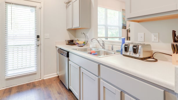 A kitchen with white cabinets, a dishwasher, a sink, and a toaster. - Pets Welcome! Family Townhome w/ Yard in Atlanta (Atlanta)