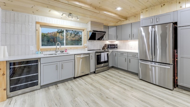 A modern kitchen with stainless steel appliances, grey cabinets, and a wooden ceiling. - Direct Trail Access: Lyons Falls Getaway w/ Views! (Lyons Falls)