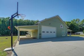 A single-story building with a garage, a covered parking area, and a basketball hoop. - Southern Comfort Near Historic Dtwn Rockmart (Rockmart)