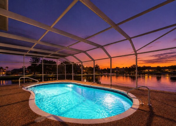 A swimming pool with a clear view of the sunset and surrounding landscape.