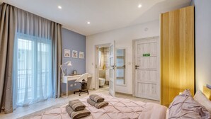 Un dormitorio con cama, escritorio y armario.