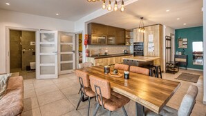 Una cocina moderna con una isla central, mesa de comedor de madera y sillas.