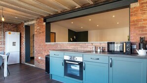 A modern kitchen with a built-in oven, microwave, and a large window above the counter. - Luxury 2 Bedroom & 2 Bathroom Central Flat (Swansea)
