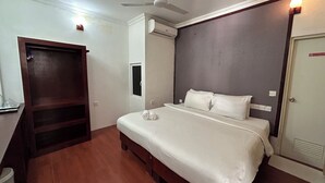 A bedroom with a bed, a ceiling fan, an air conditioning unit, and a wooden wardrobe. - Paradise peak (Maafushi)