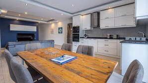 A modern kitchen with white cabinets, a built-in oven, and a microwave. - The Fives Apartment - St Julians (St. Julian`s)
